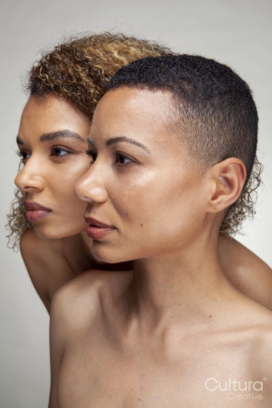 Studio portrait of two shirtless women cheek to cheek