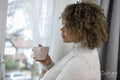 Woman with coffee cup standing by window