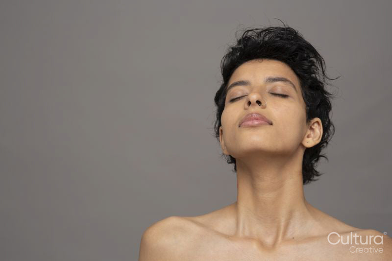 Studio portrait of shirtless woman with eyes closed