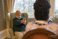 Smiling senior man exercising with nurse in nursing home