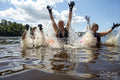 Female friends splashing water in lake, Yorkshire, UK