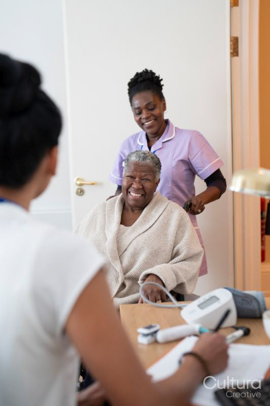 Smiling female nurse with senior woman sitting in wheelchair entering doctors office