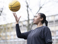 Teenage girl throwing basketball in air