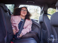 Girl fastening seat belt in car