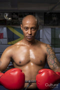 Mature man wearing boxing gloves in boxing ring, portrait