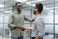Two men shaking hands in office