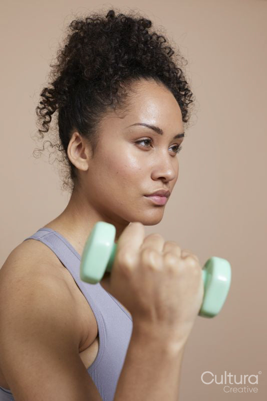 Studio portrait of woman exercising with dumbbells