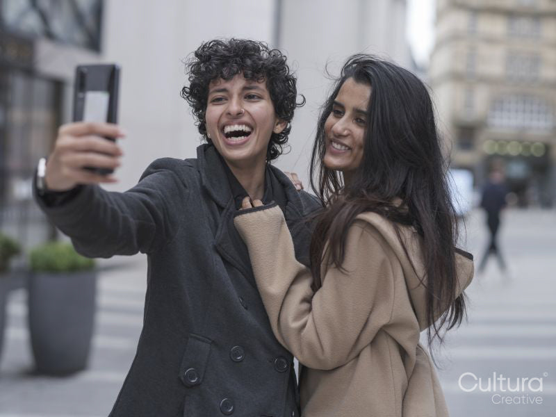 Smiling female couple taking selfie