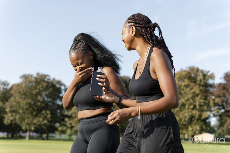 Young female friends walking in park after exercising