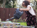 Girl watering plants in backyard