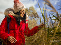 Smiling female hiker touching grass