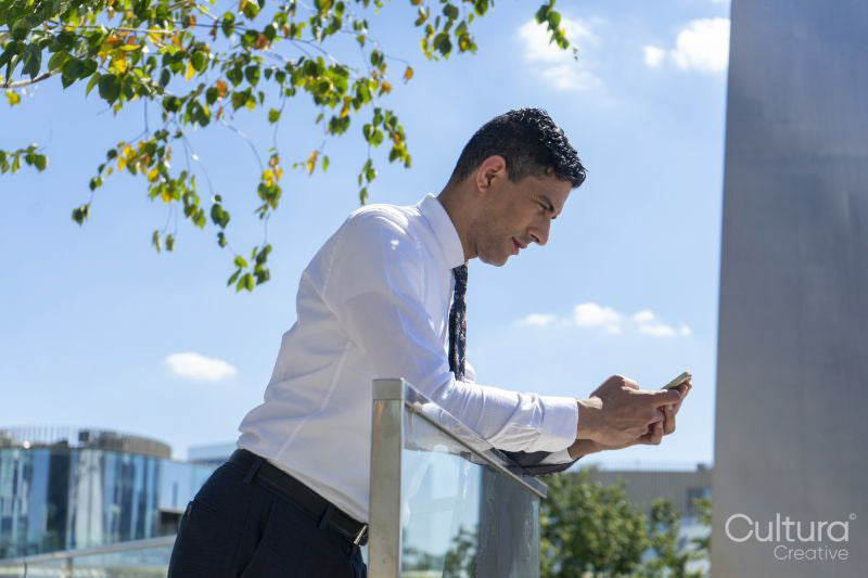 Businessman using phone outdoors
