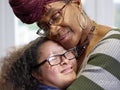 Close-up of mother hugging daughter with Down Syndrome