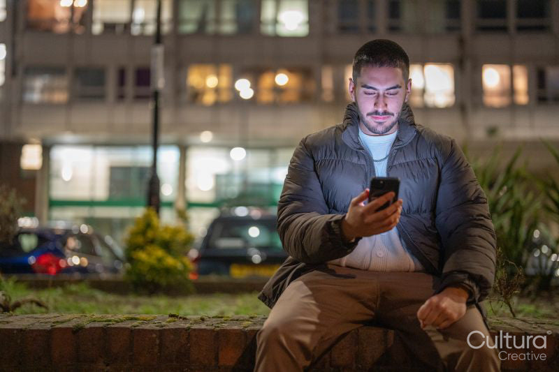 Young man using smart phone outdoors