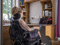 Woman in electric wheelchair working on laptop