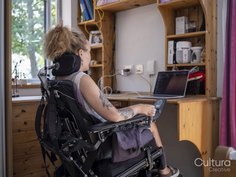 Woman in electric wheelchair working on laptop