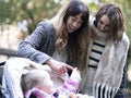 Women looking at baby in stroller at park