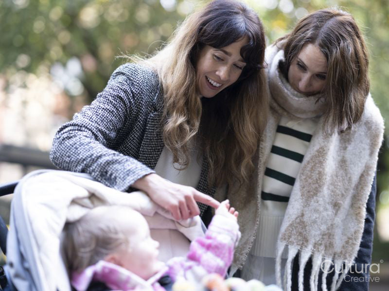 Women looking at baby in stroller at park