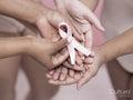 Close-up of women''s hands holding pink breast cancer awareness ribbon