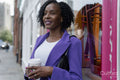 Portrait of smiling woman with disposable cup in city