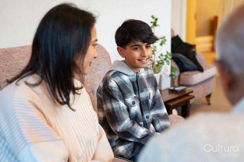 Mother and son visiting senior man in nursing home