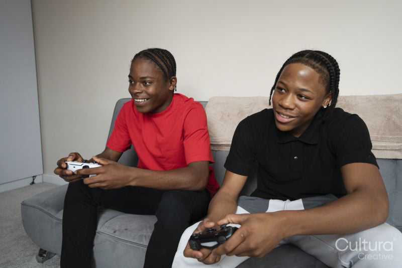 Teenage friends playing video game at home