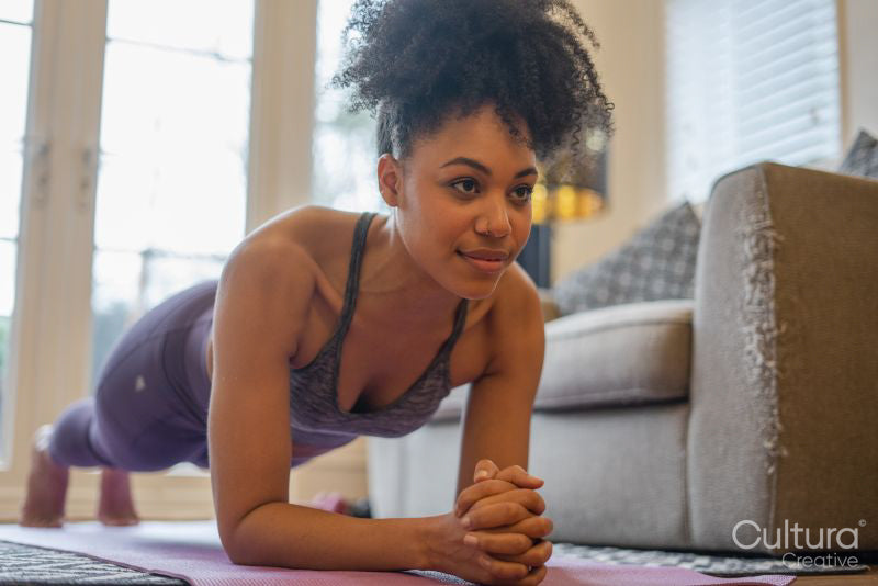 Young woman doing plank at home