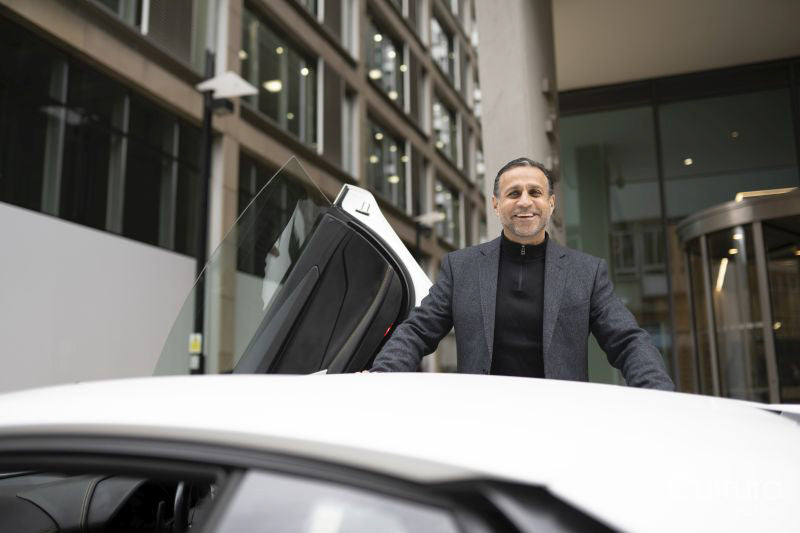 Smiling mature man leaning against luxury car