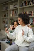Smiling mother and daughter having video call at home