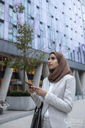 Businesswoman in hijab with smart phone in city