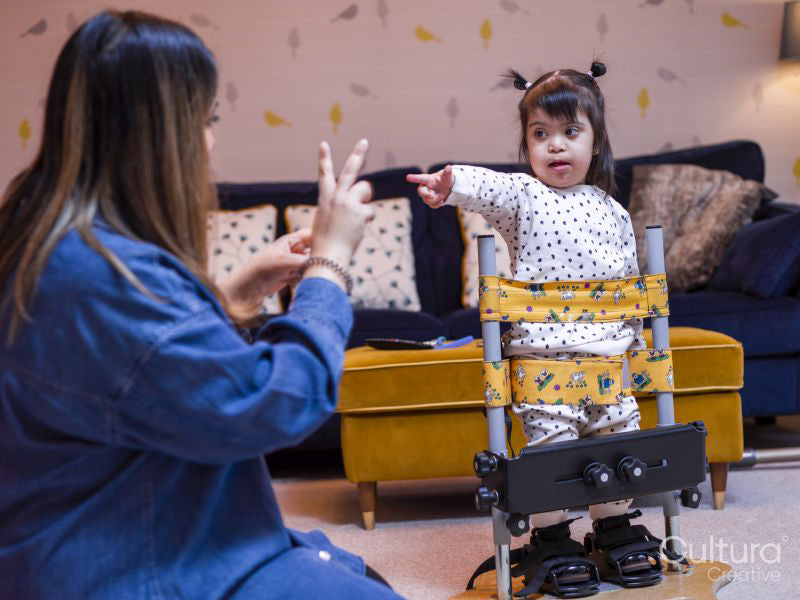 Mother playing with daughter in standing frame