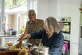 Two senior women preparing meal in kitchen