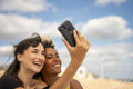 Female couple taking selfie on beach