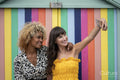 Female couple taking selfie in front of striped wall