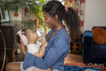 Mother holding baby daughter while drinking