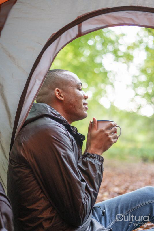 Man enjoying warm drink in tent