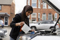 Woman wearing hijab filling water tank in car engine
