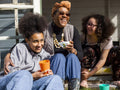 Mother with two daughters relaxing in backyard