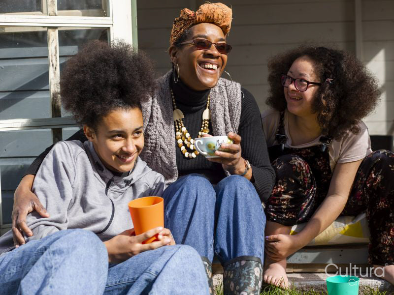 Mother with two daughters relaxing in backyard
