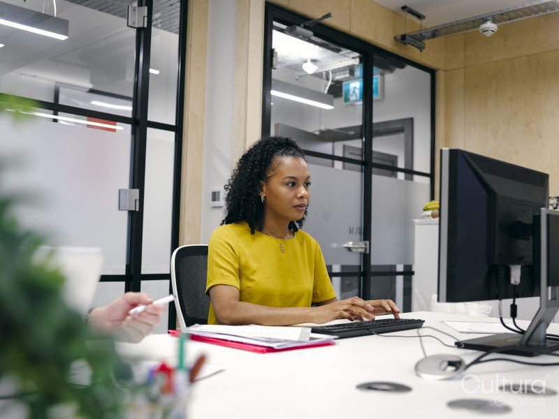 Office workers using computers in co-working office space