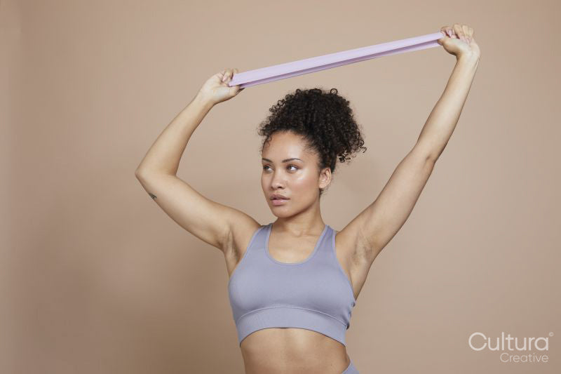 Studio portrait of athletic woman exercising with resistance band