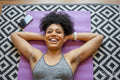 Smiling young woman lying on yoga mat
