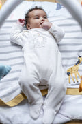 Baby girl lying on play mat at home