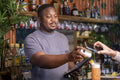 Bartender with credit car reader and tablet at bar, USUN wiek kobiety
