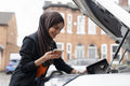 Woman wearing hijab looking into car engine