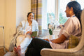 Nurse visiting senior lady in her room at nursing home