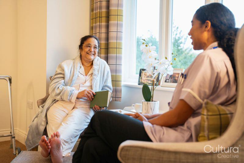 Nurse visiting senior lady in her room at nursing home