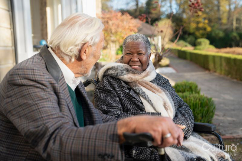 Smiling senior people relaxing on bench in park
