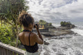 Indonesia, Bali, Female tourist photographing sea from observation point