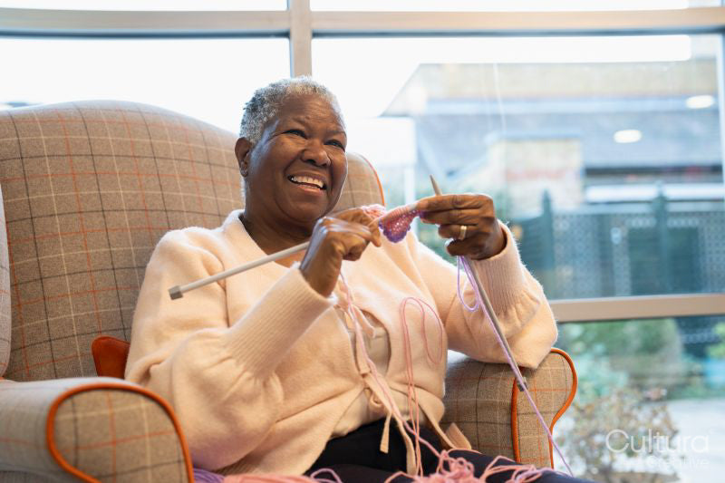 Smiling senior woman knitting in nursing home